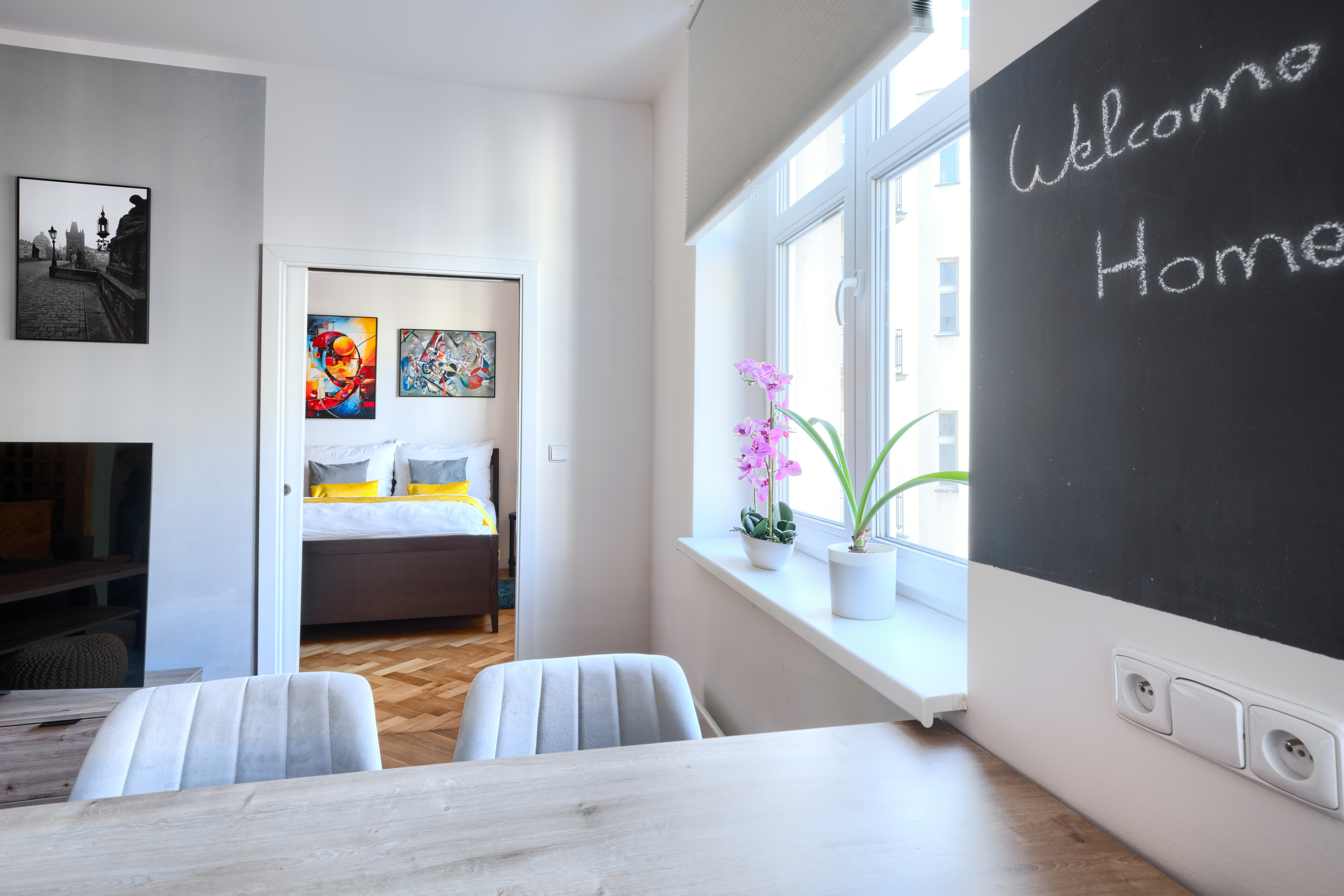 The living room with its modern furniture and natural light streaming through the windows